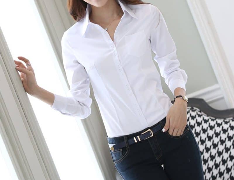 Elegant Women's Slim Fit Professional Shirt - Long-Sleeved Tailored Style 1 Woman Wearing A White Button-Up Shirt With A Collar And Long Sleeves, Paired With Dark Jeans.