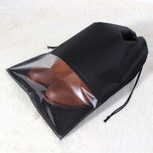 Clear plastic shoe bag with black drawstring for travel or storage.