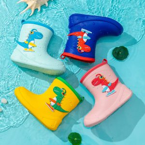 Colorful kids rain boots with playful dinosaur designs, perfect for outdoor adventures and rainy days. Bright yellow, pink, blue, and white rain boots featuring cheerful dinosaur illustrations in a pool setting.