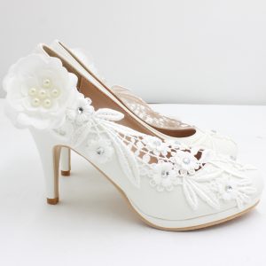 Elegant white bridal shoes with floral lace embroidery and 3D flower embellishments, perfect for weddings and special occasions. High heels with intricate design and rhinestone accents from Syndmart.
