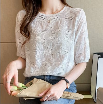 Fashion-forward: Women's Chic Embroidered Chiffon Shirt - Stylish & Breathable 5 Woman Wearing A White Floral Lace Top With A Round Neckline, Holding A Bouquet Wrapped In Paper.