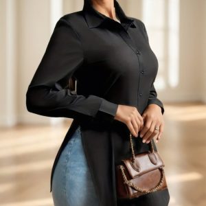 Woman wearing a black button-up shirt and holding a brown handbag.