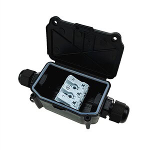 Rainwater harvesting system components, including a black plastic tank with inlet and outlet pipes, designed for sustainable water collection and management.