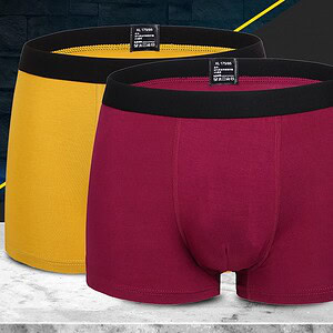 Two pairs of men's boxer briefs, one yellow and one burgundy, displayed on a surface.