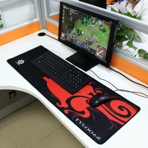 Gaming setup with gaming monitor, keyboard, mouse, and mouse pad featuring a dragon design for esports and online gaming Enthusiasts; computer desk in modern office environment.