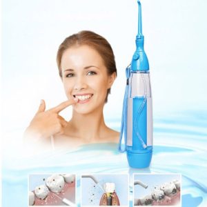 A woman smiling while using a portable oral irrigator with a blue water tank.