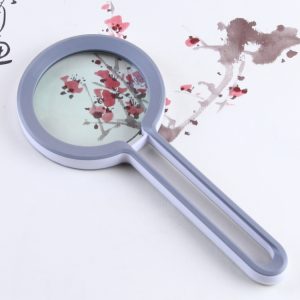 Magnifying glass with a round lens and a gray handle, featuring a floral design on the lens.