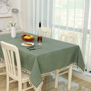 Green tablecloth with white polka dots and tassels, dining table setup, kitchen interior, modern home decor, syndmart featured product, dining room furniture, table setting with wine and fruit, cozy home living, stylish table linens, kitchen and dining accessories.