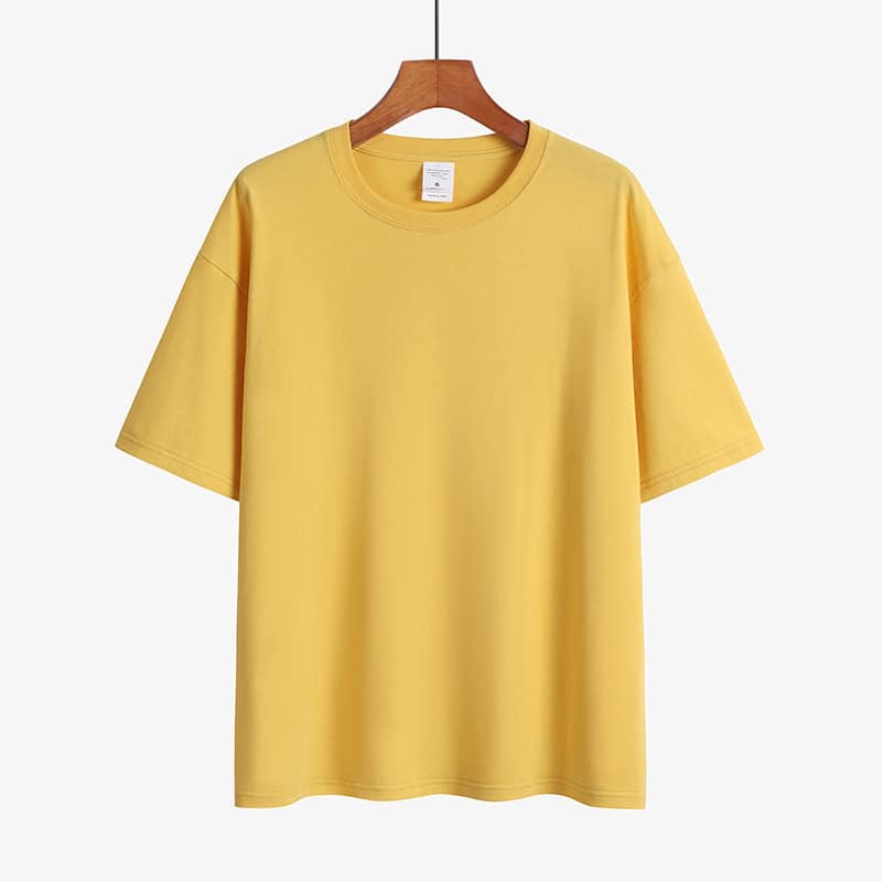Classic Round Neck Drop Shoulder T-Shirt - Comfort meets Style! 11 Plain Yellow Short Sleeve T-Shirt Displayed On A Wooden Hanger Against A White Background.