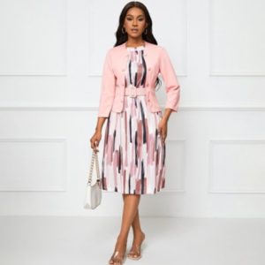 Stylish woman in pink blazer and patterned dress, presenting modern women's fashion and chic office wear for professional and casual occasions.