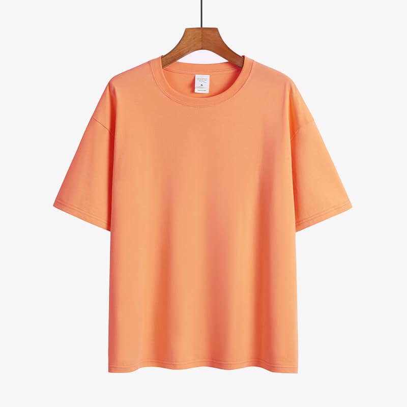 Classic Round Neck Drop Shoulder T-Shirt - Comfort meets Style! 12 Light Orange Short Sleeve T-Shirt Displayed On A Wooden Hanger Against A Plain Background.