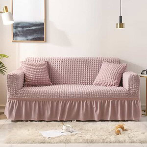 Soft pink textured sofa with matching cushions in modern living room, featuring stylish art, cozy ambiance, and elegant decor, perfect for home comfort.
