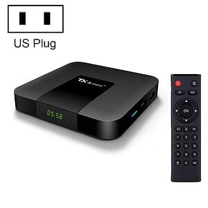 Black Android TV box with a digital display and a remote control beside it.