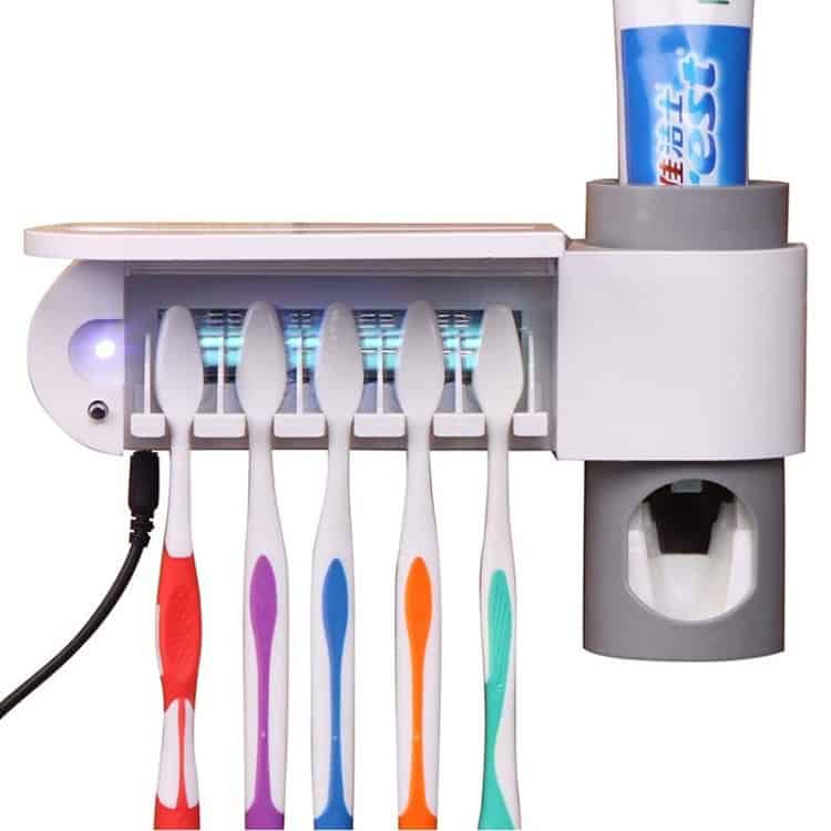 UV Toothbrush Sterilizer & Automatic Toothpaste Dispenser with Storage Holder 3 Uv Toothbrush Sterilizer And Charger Holding Five Toothbrushes With Colorful Handles, And A Tube Of Toothpaste On Top, Showcasing Dental Hygiene And Sanitation Products.