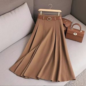 High-Quality Beige Pleated Skirt With Belt, Stylish Handbag, And Matching Accessories Displayed On A Sofa, Perfect For Fashion-Forward Outfits And Wardrobe Essentials.