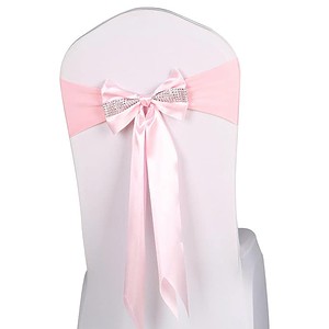Luxurious chair cover with pink satin sash and rhinestone bow for elegant events.