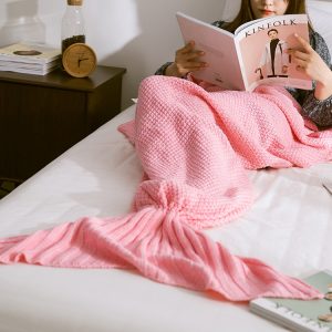 Soft pink mermaid tail blanket for cozy home lounging and reading relaxation, perfect for children and adults, made of warm knitted material to stay comfortable.