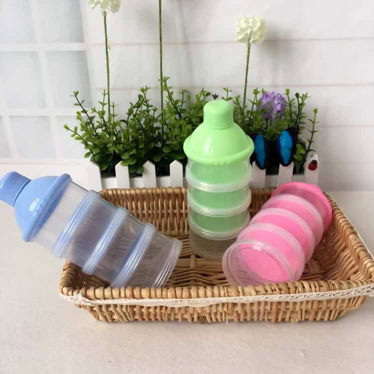 Portable Baby Milk Powder Formula Dispenser & Storage Container - Feed on the Go! 10 Plastic Baby Food Storage Containers With Colored Lids On Woven Basket In Front Of Potted Flowers, Perfect For Storage And Organization, Featured On Syndmart Online Store, High-Quality Kitchen Accessories Seo Optimized Image.