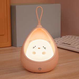 Soft pastel pink cat-shaped bedside lamp with warm glow, perfect for children's bedrooms or nurseries, creating a cozy and calming atmosphere for sleep or relaxation.