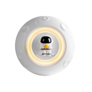 A cute astronaut figurine on a moon-themed night light with soft glowing ring, perfect for space-themed decor or children's bedrooms.