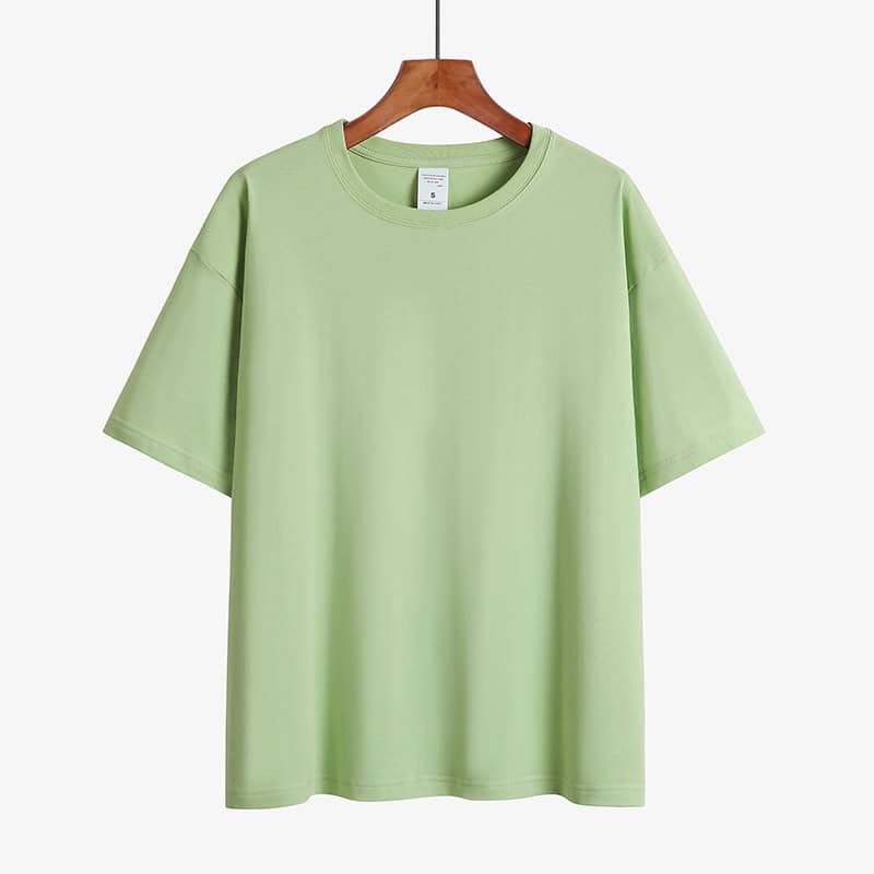 Classic Round Neck Drop Shoulder T-Shirt - Comfort meets Style! 10 Light Green Short Sleeve T-Shirt Hanging On A Wooden Hanger Against A Plain Background.