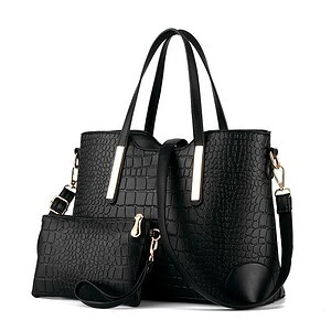 Black crocodile-embossed tote bag with matching wristlet and removable shoulder strap, perfect for fashion-forward women. Stylish and functional accessory for daily use.